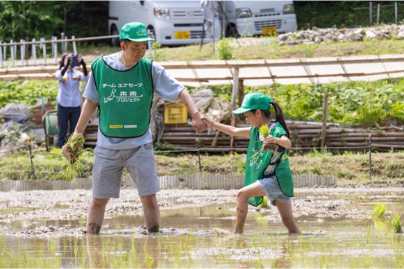 泥だらけになりながら田植え